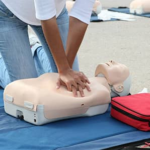 Female instructor showing CPR on training doll